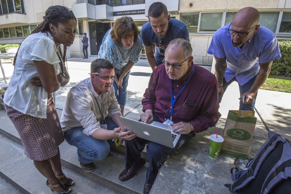 Photographer Grant Baldwin captures a unique moment on Thursday afternoon and captions: "QNotes Editor Matt Comer (center left) along with Clerk Of Court David Granberry (center right) closely monitor a public database of court filings for a verdict that would legalize LGBT marriage in North Carolina. Scott Lindsley along with his partner Joey Hewell (Right to Left) watch with anticipation, ready to receive their marriage license once the verdict is passed down. They are accompanied by Scott's mother Carol Hopkins. Crystal Richardson, Dir. Of Advocacy And Outreach for Equality NC stands on the far left."