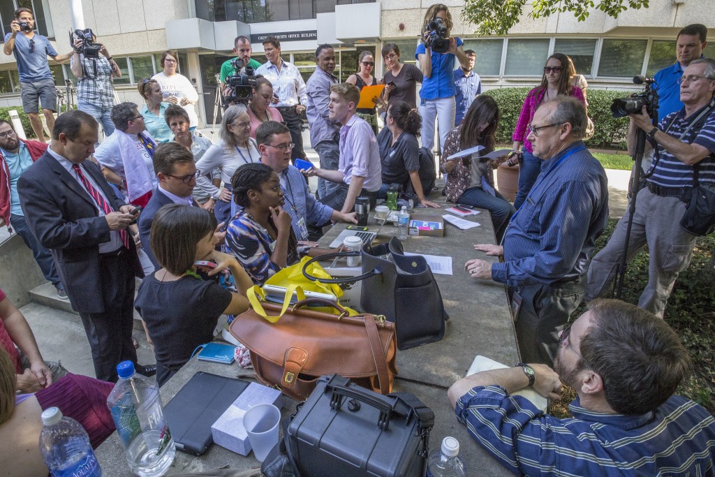 Photographer Grant Baldwin captures Mecklenburg Register of Deeds David Granberry, right, updating a growing crowd of media and onlookers.